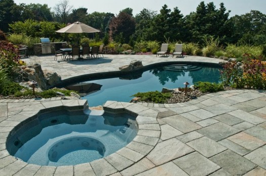Spa/Pool Combinations: In this project, the spa constantly fills up with, and circulates, pool water. Then this water falls via the spa’s spillover channel back into the pool. The upgrade expanded this spillover into a larger waterfall and added boulders to create a more beautiful scene.
