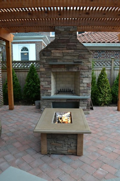 Outdoor Wood-burning Fireplace: This new wood-burning fireplace is made in cultured stone: Country Ledgestone, in the color “Bucks County.” The fire pit table is “Snowbird” made with a stainless steel burner; its clear fire jewels appear to be bubbling when the flame is lit.