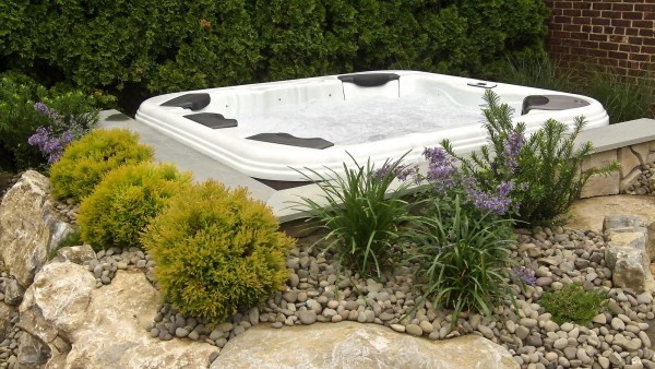 Hot Tub Hydrotherapy: Lastly, the complete set-in-garden look includes river rock along with additional colorful plants. Note: In this close up shot of the installation, you can see Bullfrog Spas’ interchangeable massage seats/jets called JetPaks — well known for providing some of the best massages available in a portable spa. 