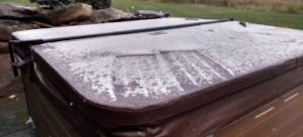 Ice covered hot tub cover and hot tub installed in backyard and is not close to the house