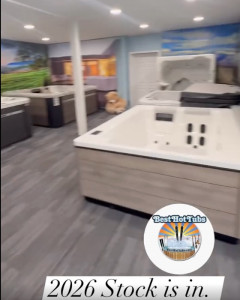 Inside Best Hot Tubs showroom loaded with spas, with various colored shells, one being beige, others being dark brown; can see the jets inside the hot tubs, too